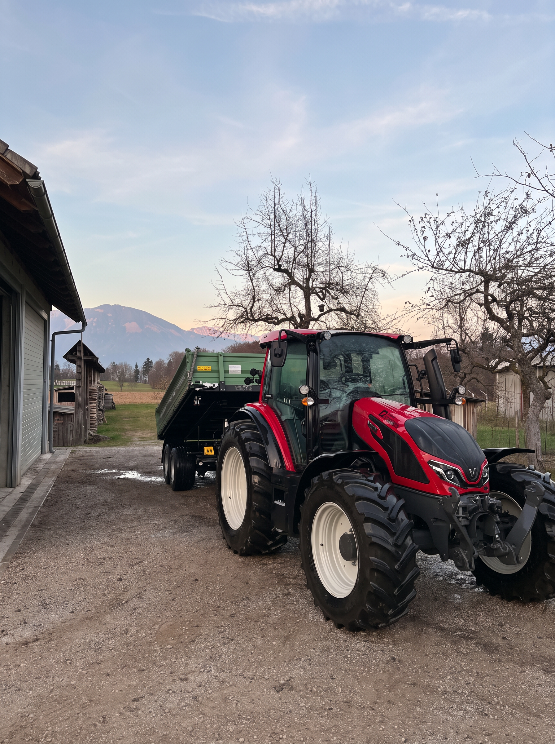 Rdeči traktor s prikolico na gradbišču